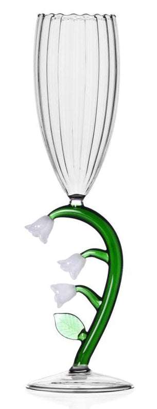 A clear glass fluted champagne flute with a decorative green vine and white lily of the valley flower motif on the stem, set against a plain white background.