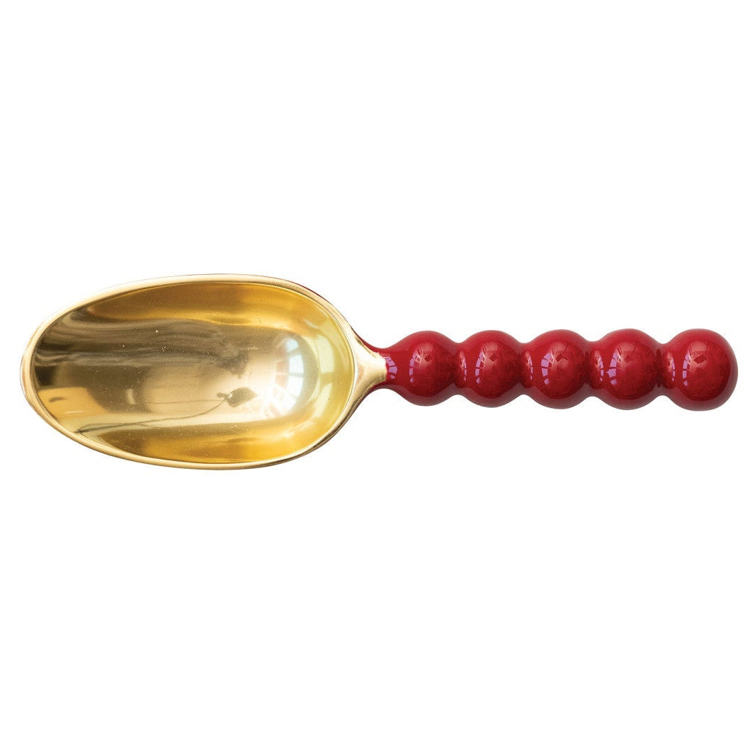 Gold spoon with a red handle on a white background