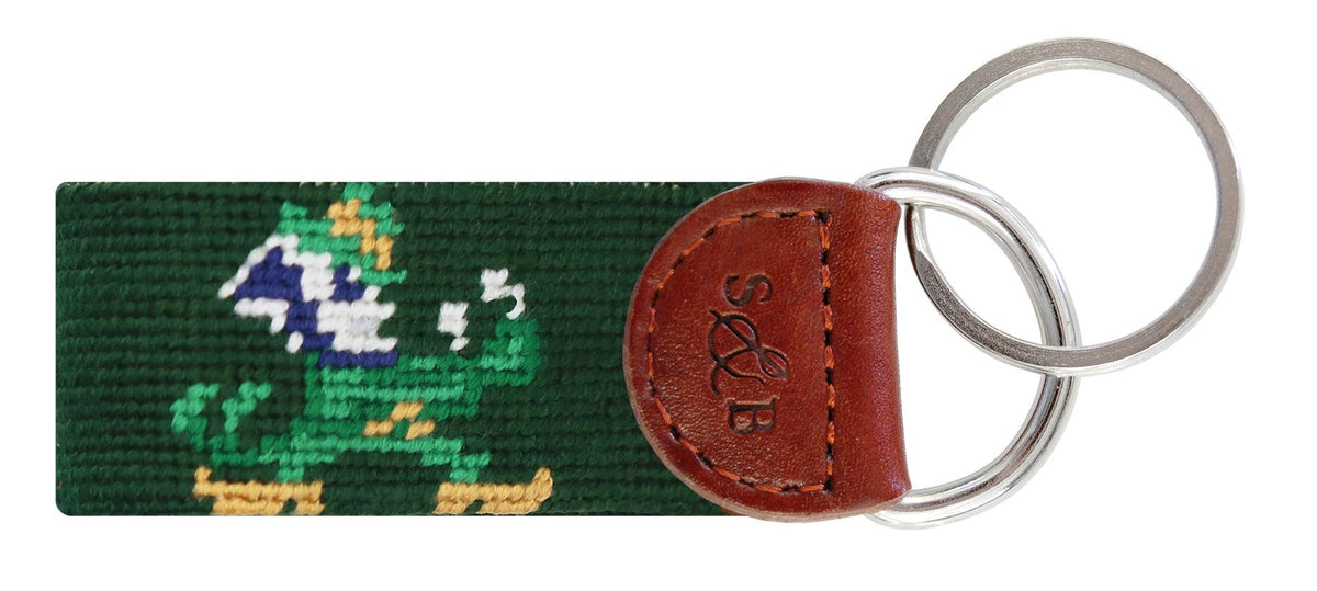 Keychain with green fabric strip featuring a design and brown leather patch on a white background