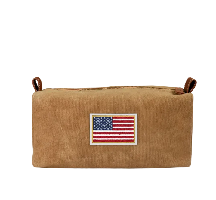 Brown leather pouch with American flag patch on a light gray background