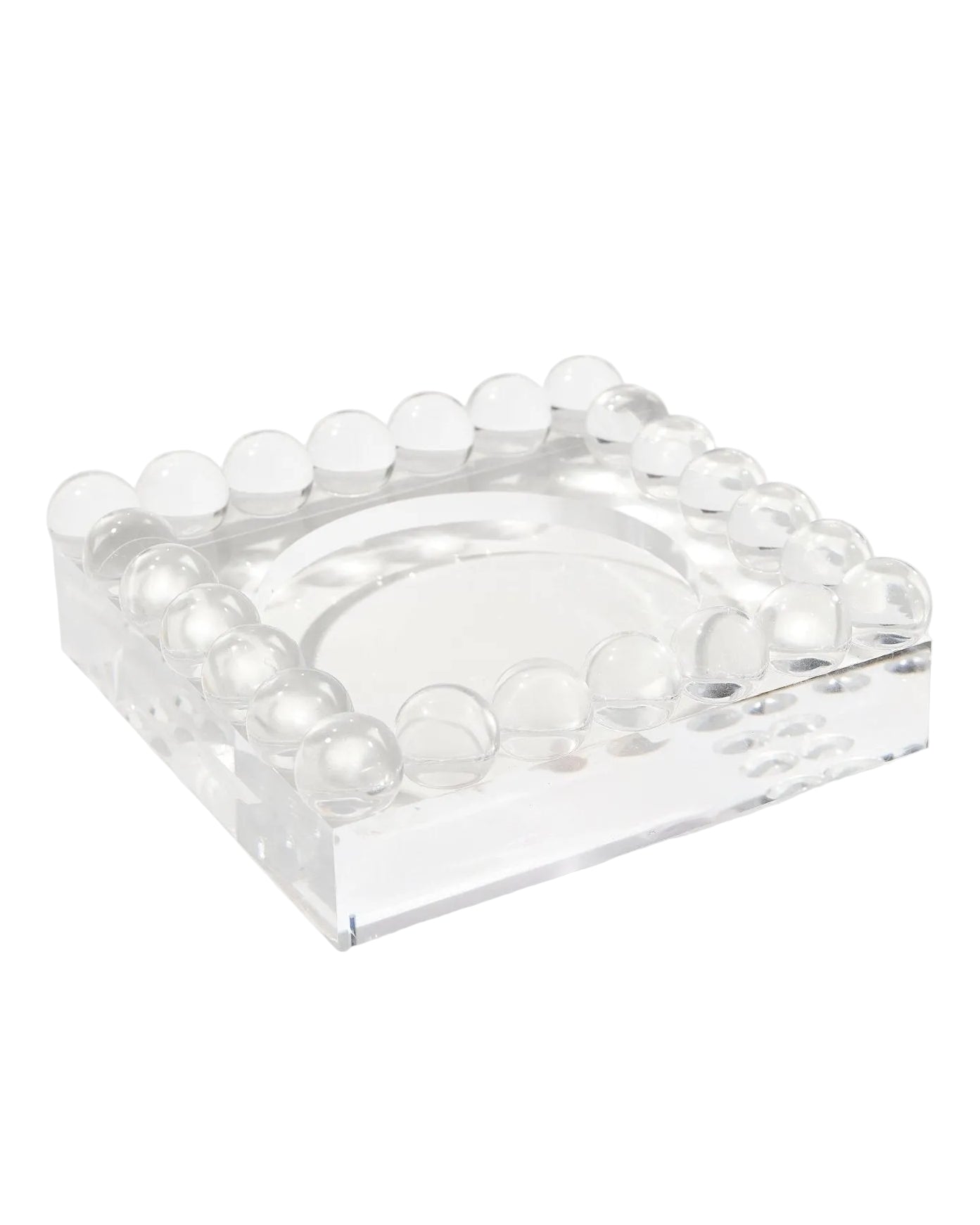 Clear square glass object with embedded round elements on a white background