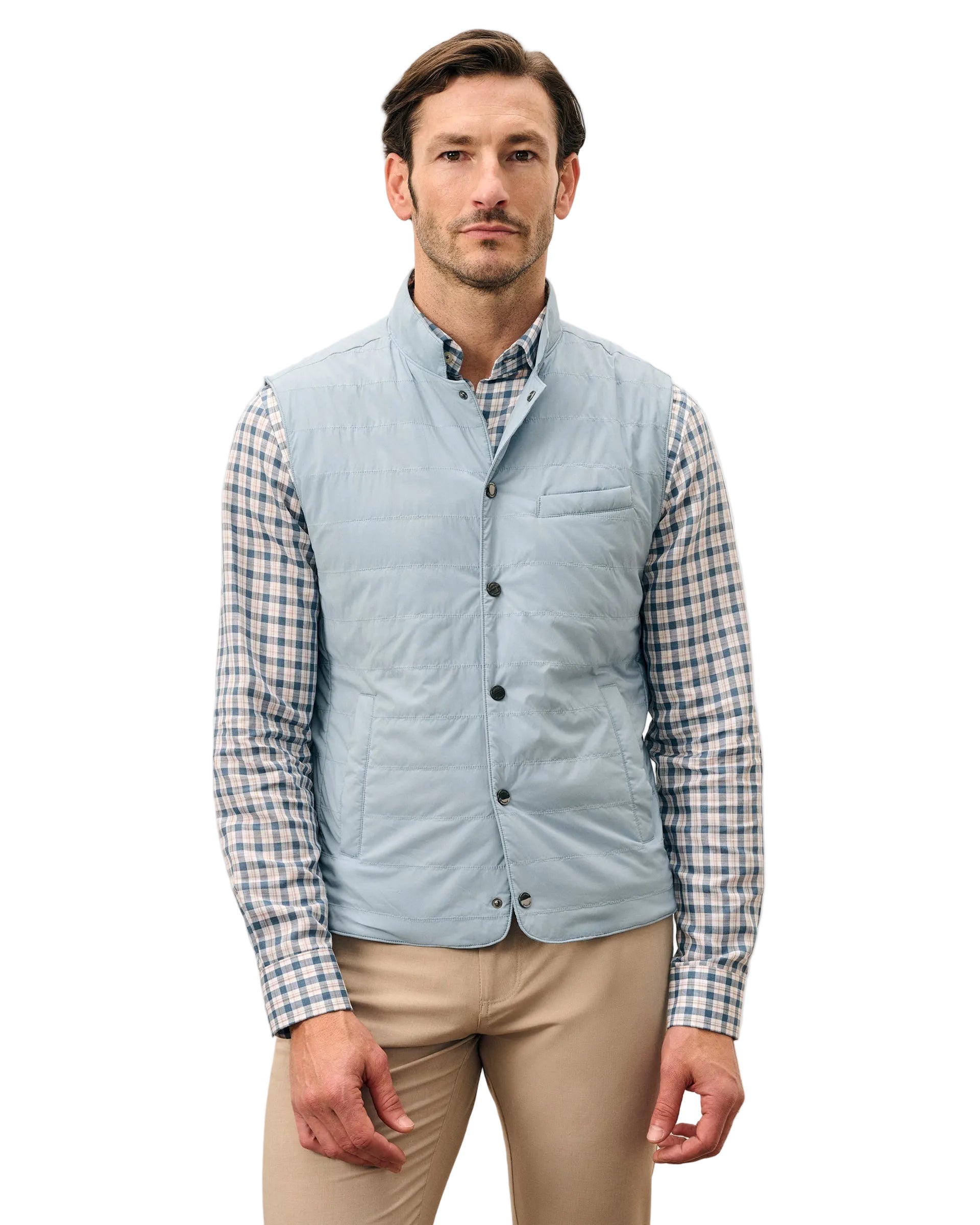 Man wearing a light blue quilted vest over a plaid shirt on a white background