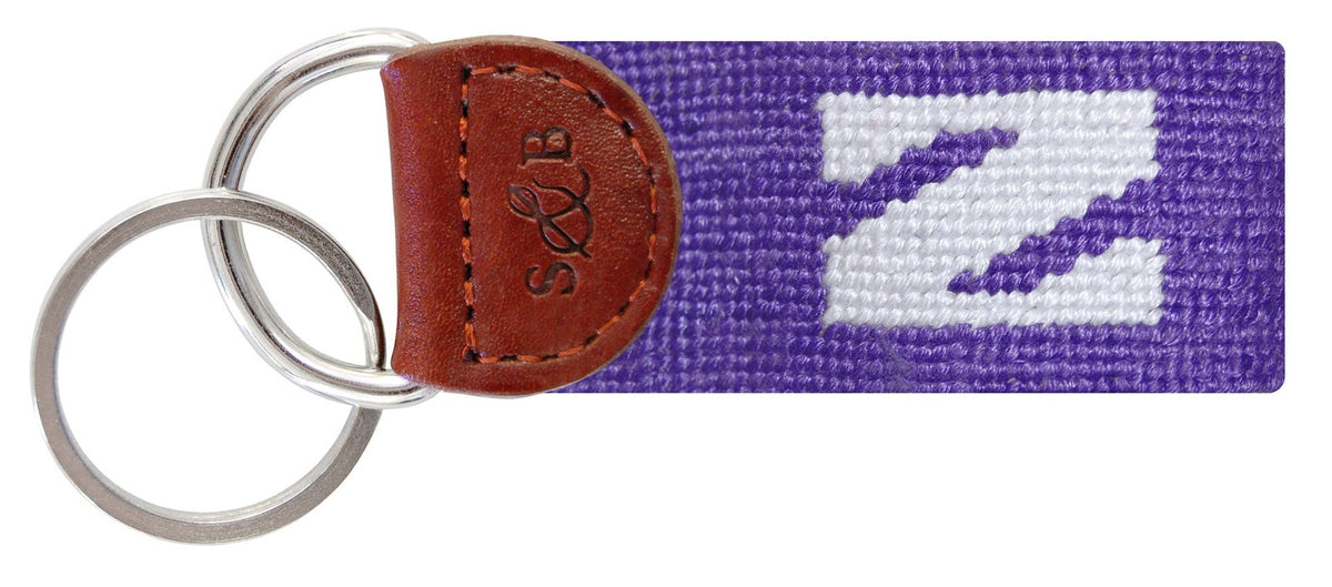 Keychain with purple strap and white logo on a white background