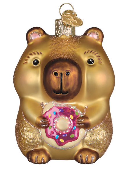 Gold bear ornament holding a pink donut with sprinkles on a white background
