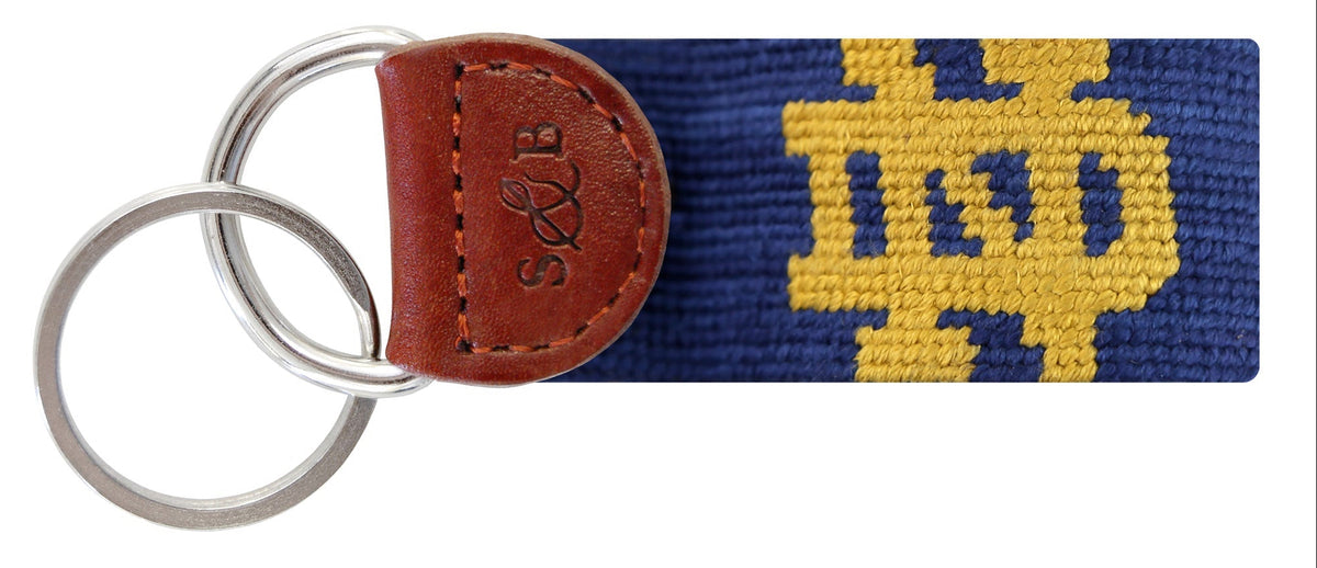 Keychain with brown leather tag and blue strap with yellow logo on a white background