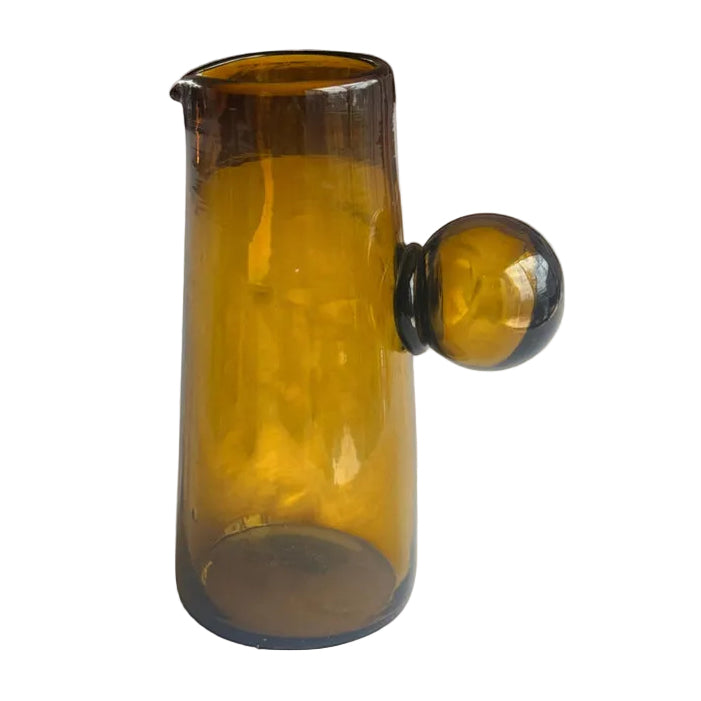 Brown glass pitcher on a beige background