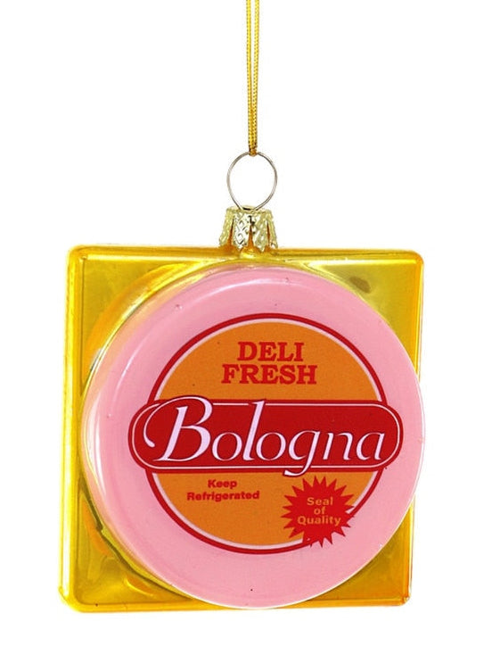 A novelty Christmas ornament shaped like a square gold container holding a pink round label that reads 'Bologna Deli Fresh' in red and white text, hanging from a gold string against a white background.