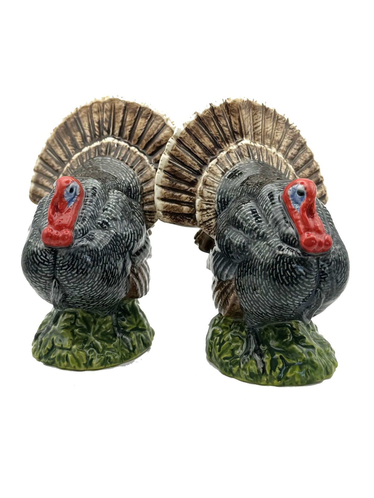 Two decorative turkeys with fan-shaped feathers on a white background