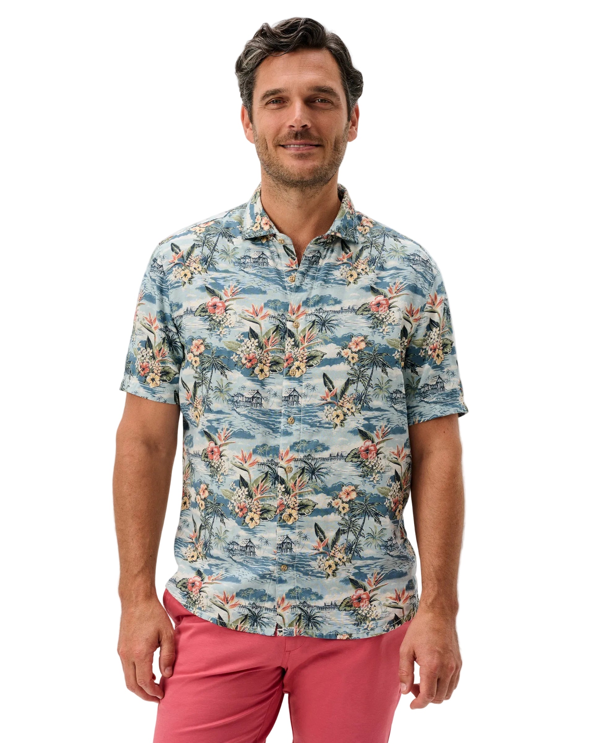 Man wearing a floral patterned shirt and pink pants on a white background
