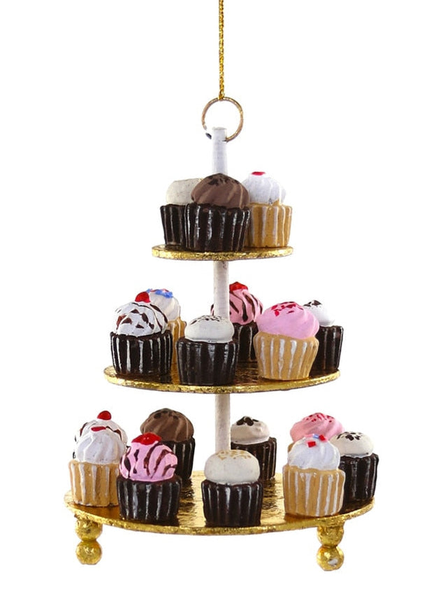 A three-tiered gold cupcake stand with a white central pole and gold hanging ring, decorated with miniature cupcakes, on a plain white background.