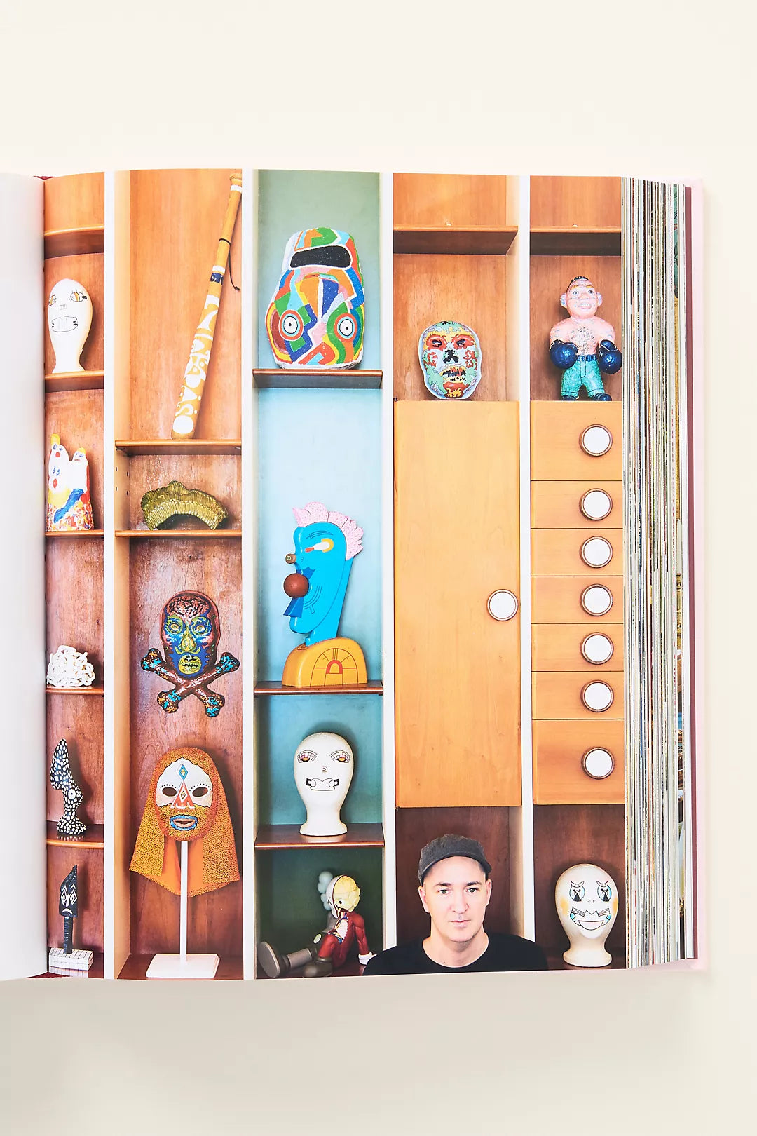 Book with colorful illustrations of masks and a person on a shelf
