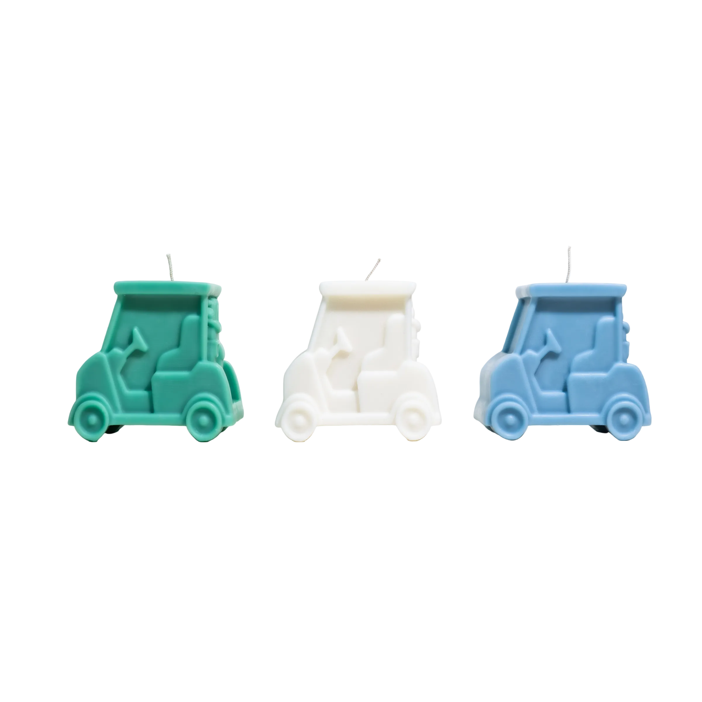 Three toy car-shaped candles in teal, white, and blue on a light gray background