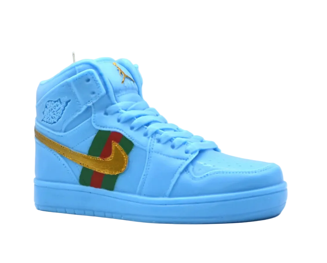 A candle designed to resemble a blue high-top sneaker with decorative gold and red patterns on it.