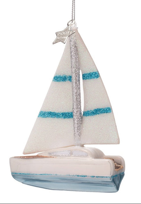Decorative sailboat ornament with striped sails on a white background