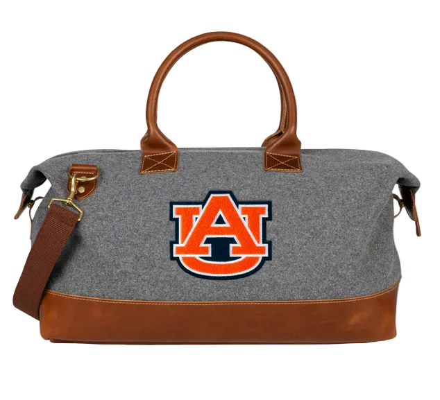 A gray Auburn University weekender duffle bag with brown leather accents, featuring a chenille 'AU' patch, rolled leather handles, and a traditional orange 'AU' patch on the side.