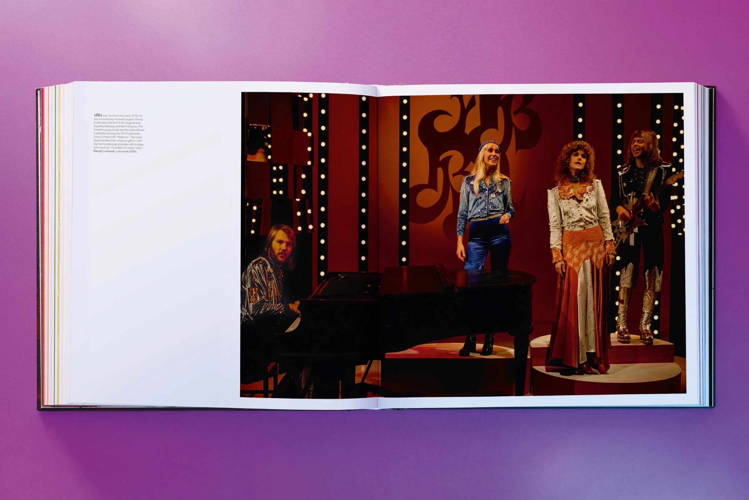 Open book showing a stage scene with people on a purple background