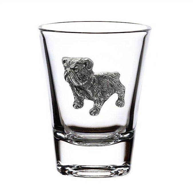 A clear glass shot glass featuring a detailed silver pewter engraving of a bulldog on the front, set against a plain white background.