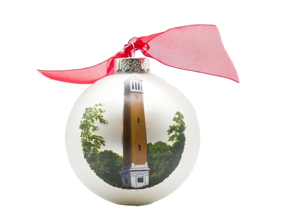White ornament with a lighthouse design and red ribbon on a white background