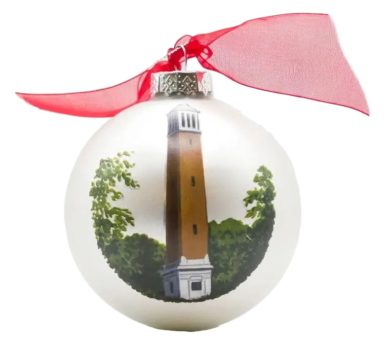 White ornament with a lighthouse design and red ribbon on a white background