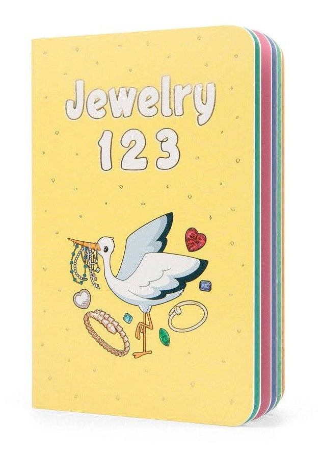 A yellow notebook or journal titled 'Jewelry 123' with a whimsical illustration of a white bird carrying jewelry, shown on a clean white background.