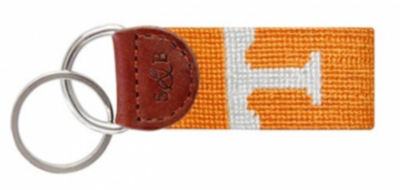 A hand-stitched needlepoint key fob with an orange and white Tennessee 'T' logo, lined with full grain Italian leather and a looped strap.