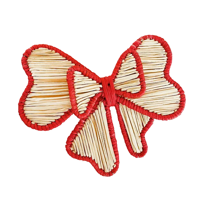 A red trimmed bow-shaped napkin ring made from woven Iraca palm.