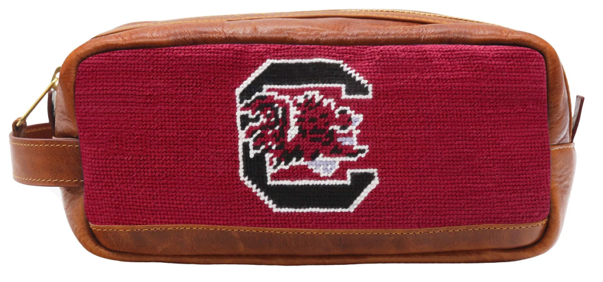 A red and brown Smathers & Branson toiletry bag with a needlepoint design featuring a lion and the text 'South Carolina'.
