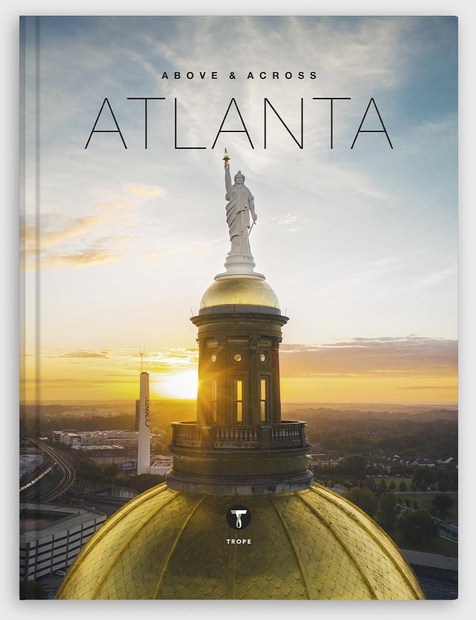 Book cover of 'Above & Across Atlanta' with a statue and cityscape.