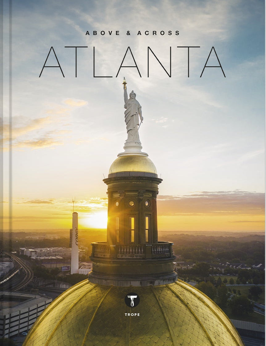 Book cover of 'Above & Across Atlanta' with a statue and cityscape.