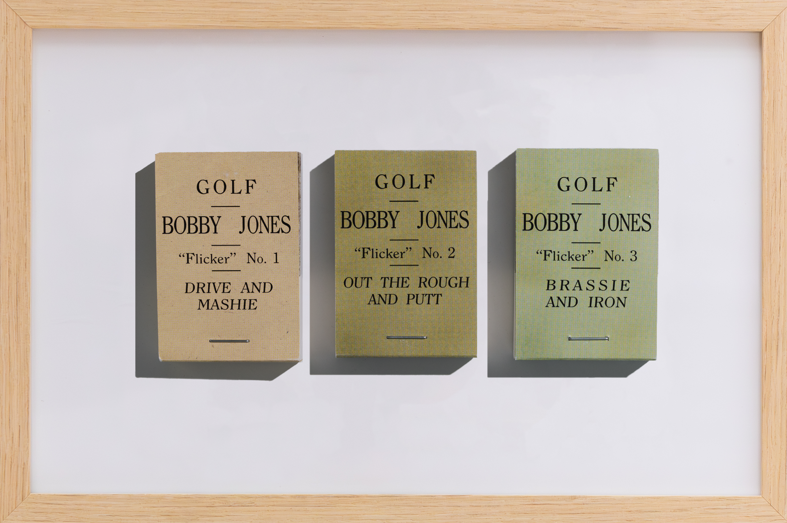 Three framed golf scorecards by Bobby Jones on a white wall.