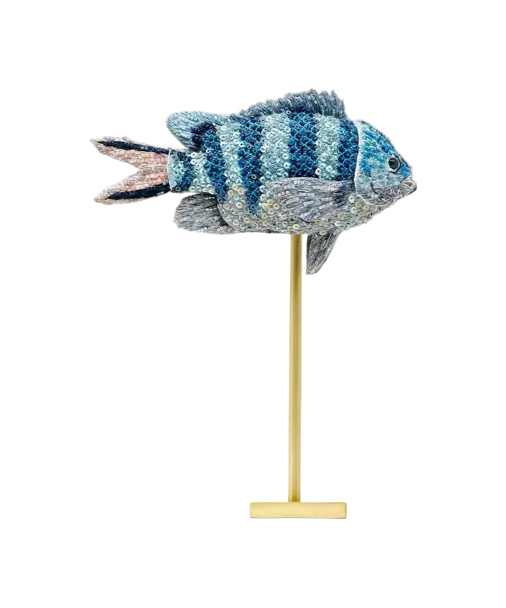 Decorative fish sculpture on a stand with a white background