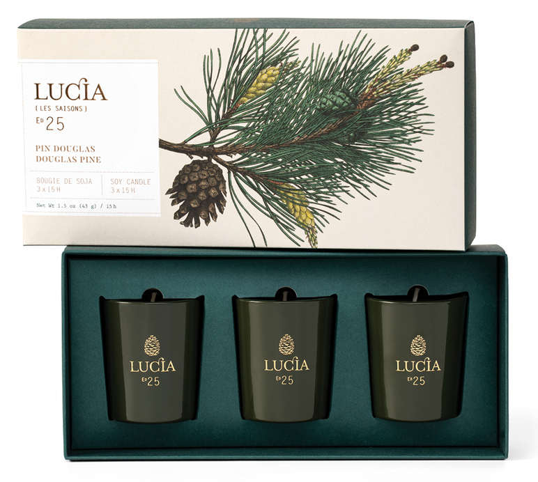 Set of three black candles in a box with a decorative label featuring pine branches and cones, branded 'Lucá'.