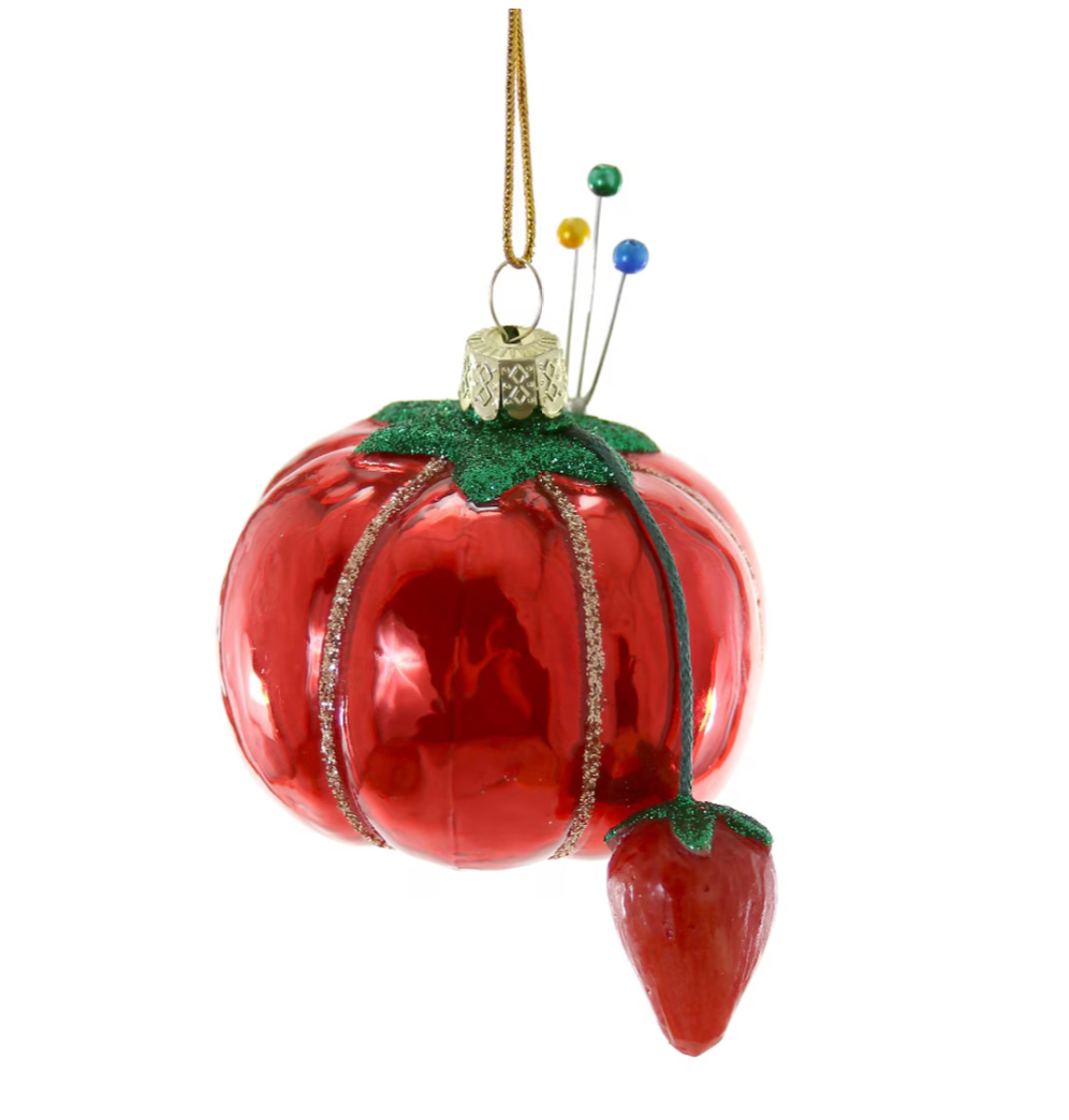 Decorative tomato pin cushion ornament with green stem on a white background