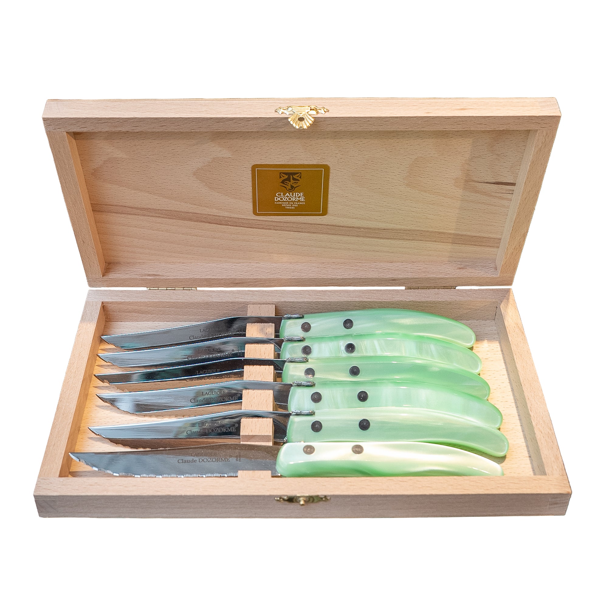 Set of knives with green handles in a wooden box on a white background
