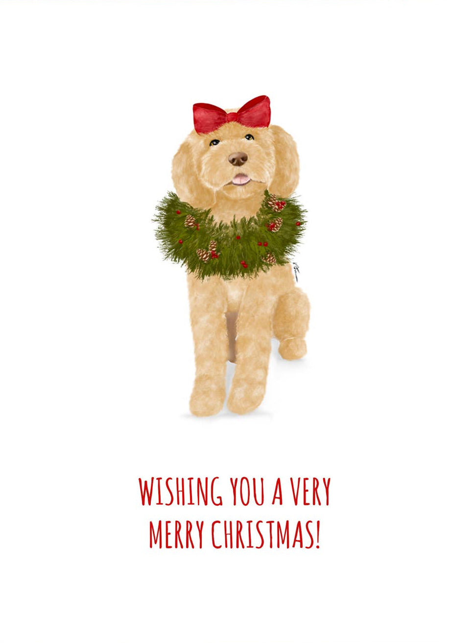 A Christmas greeting card with a white front featuring an illustration of a tan dog wearing a green wreath and red bow, with red text reading 'WISHING YOU A VERY MERRY CHRISTMAS!'. A red envelope is placed behind the card on a light neutral background.