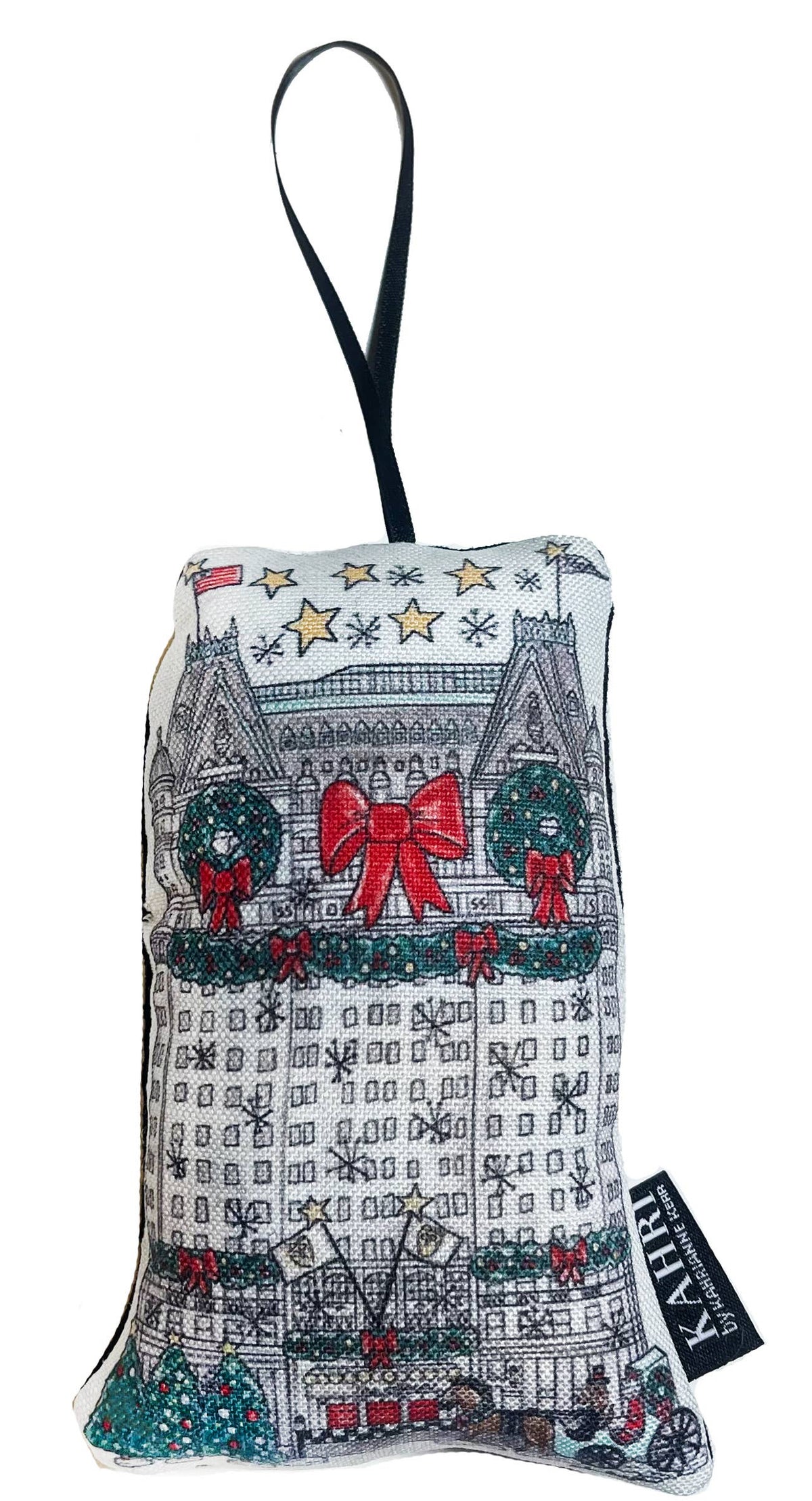 A fabric hanging bag with a black strap, featuring a printed illustration of a grand building decorated for Christmas with green wreaths, red bows, and gold stars. A black fabric tag on the side reads 'LUX'.