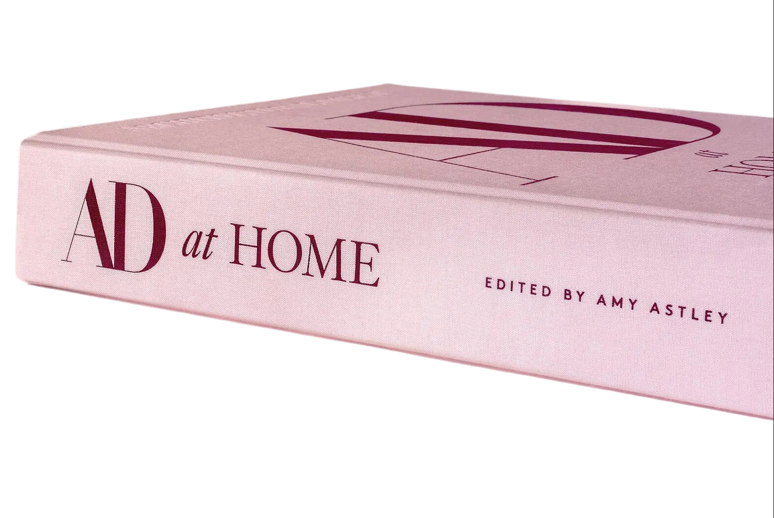 Pink book titled 'AD at Home' edited by Amy Astley on a white background