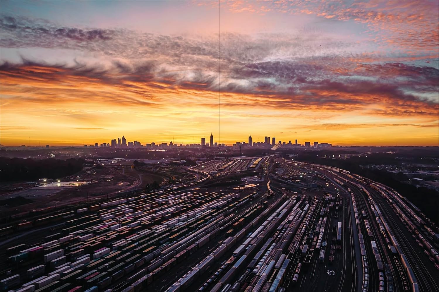 Aerial view of a Atlanta cityscape with a sunset sky over a highway system.