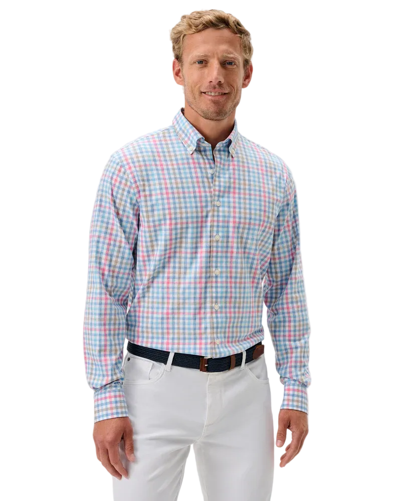 Man wearing a plaid shirt and white pants on a light gray background