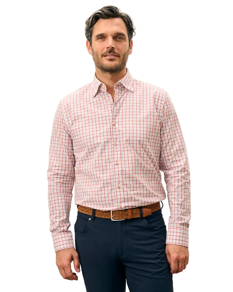 Man wearing a red and white checkered shirt with navy pants on a light gray background