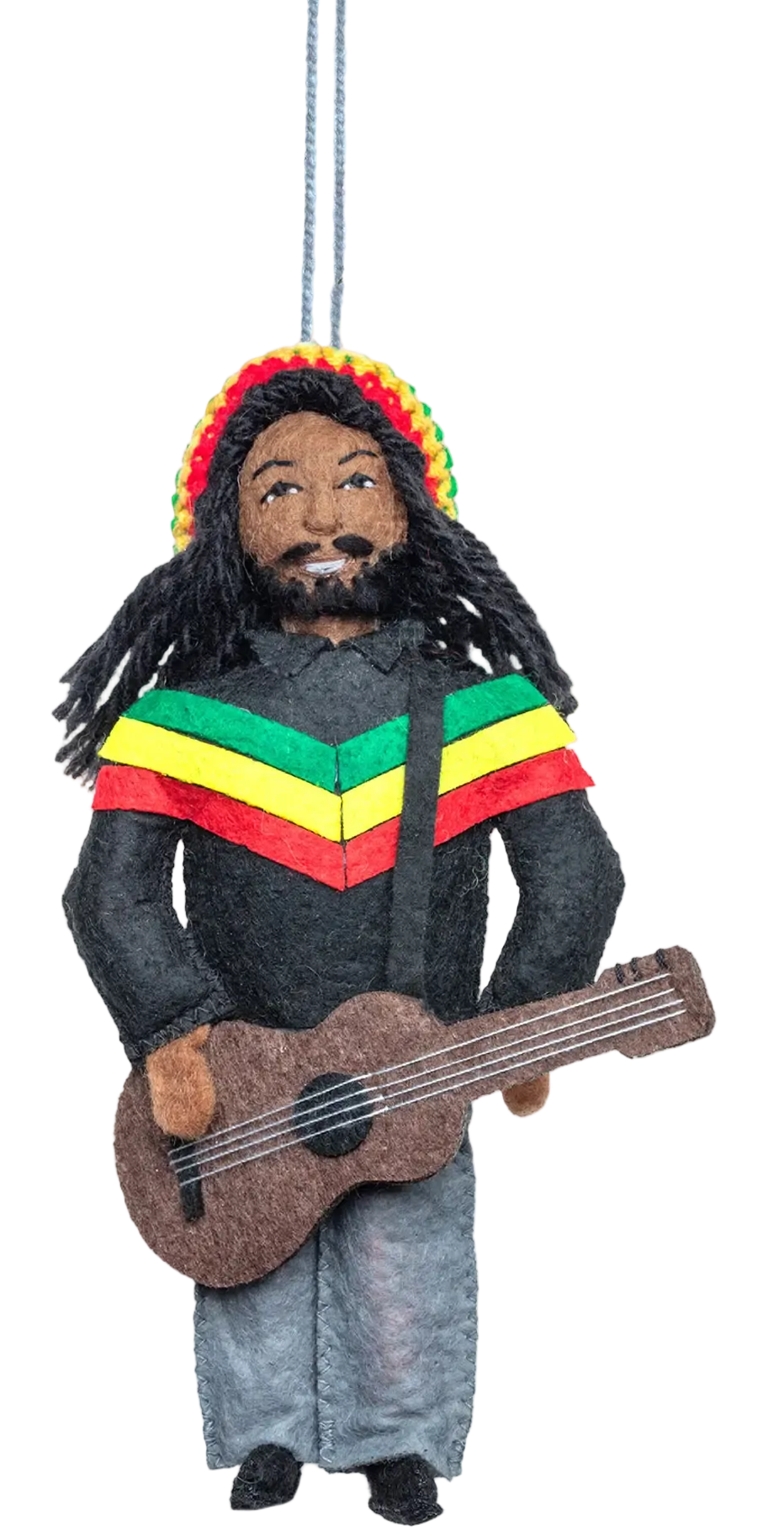 A hanging Christmas ornament shaped like a Rasta musician with dreadlocks, a colorful striped sweater, and a guitar, suspended from a pine branch against a white background.