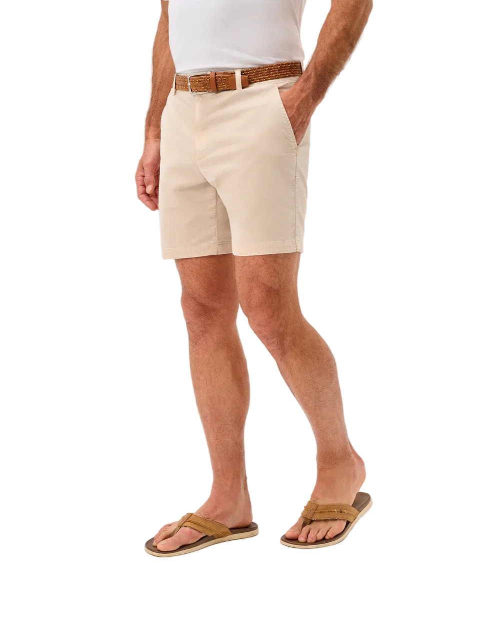 Person wearing beige shorts and brown sandals on a white background