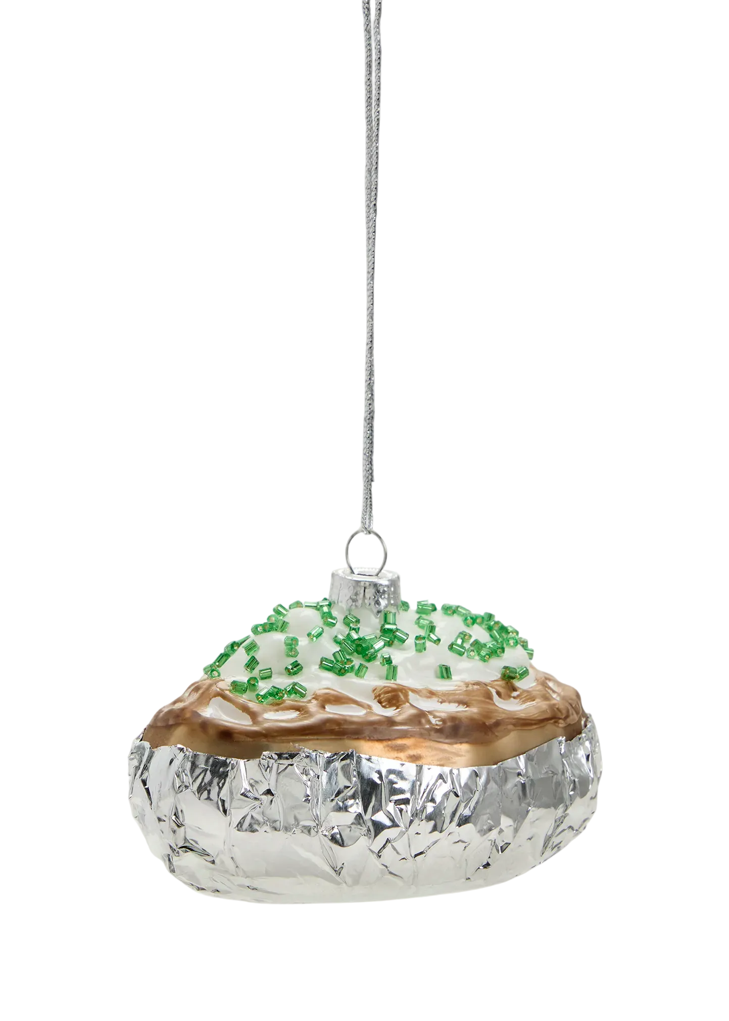 Decorative glass ornament with gold base and greenery on a white background