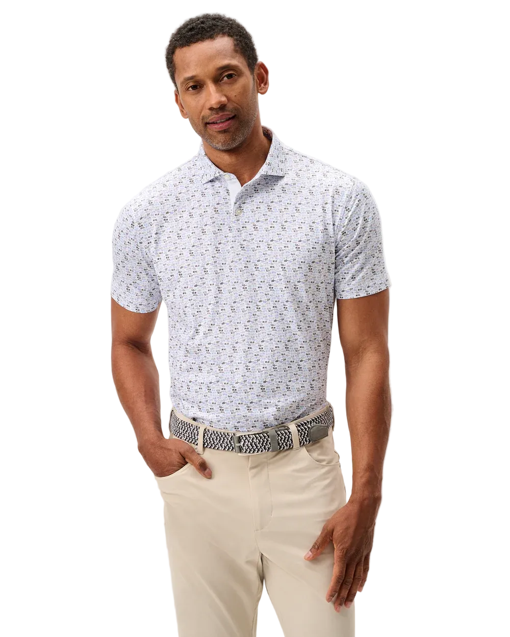 Man wearing a patterned short-sleeve shirt and beige pants on a light gray background