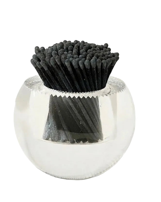 Clear glass container with black bristle brush on a white background