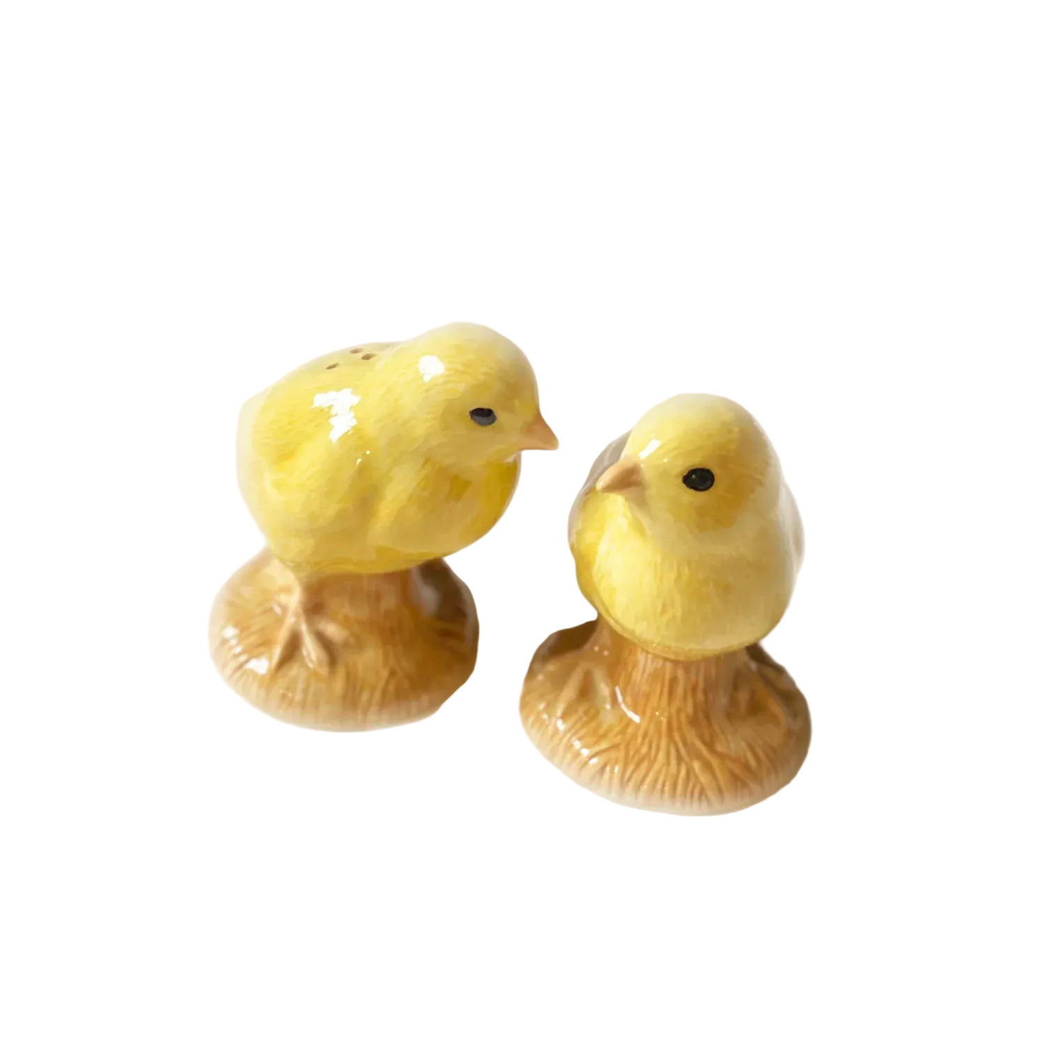 Two yellow ceramic chicks on a light beige background