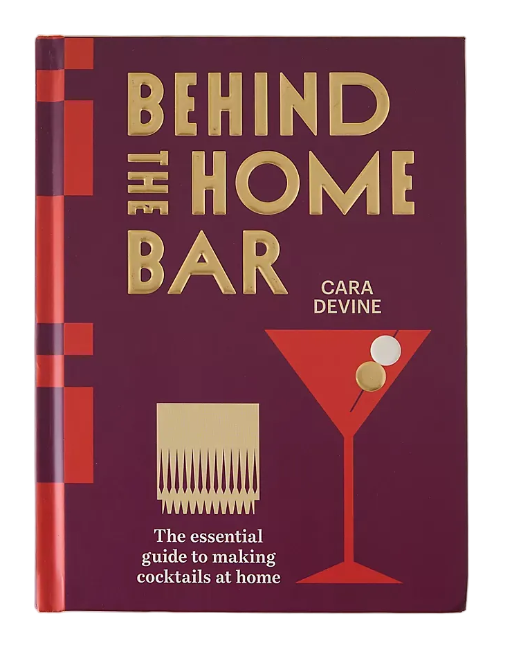 The book cover of 'Behind the Bar' by Cara Devine, featuring a deep burgundy background with gold lettering and a red and gold cocktail glass illustration, set against a light beige background.