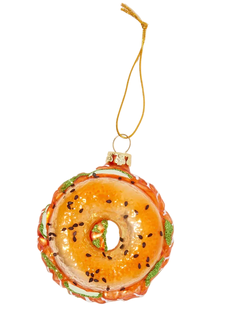 Decorative donut ornament with a gold string on a light beige background