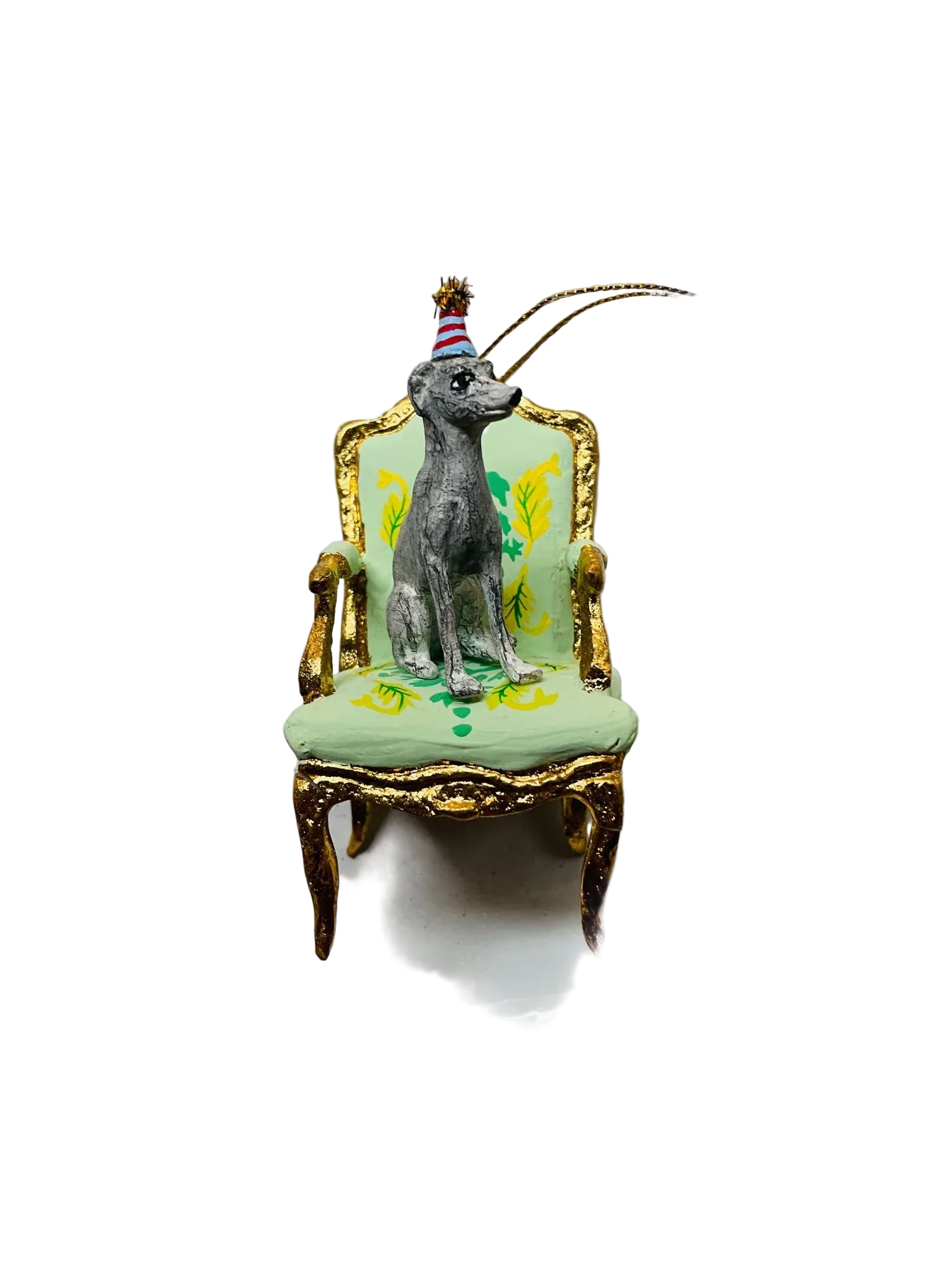 Decorative ornament with a dog on a chair, sitting on a scalloped edge plate.