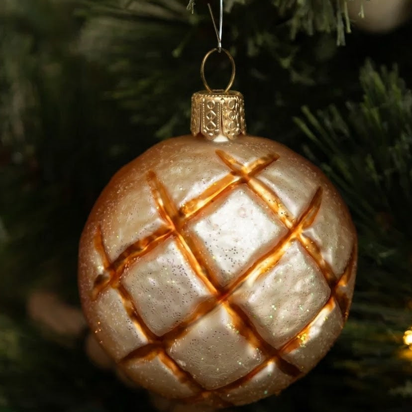 Decorative Christmas ornament with gold lattice pattern on a tree